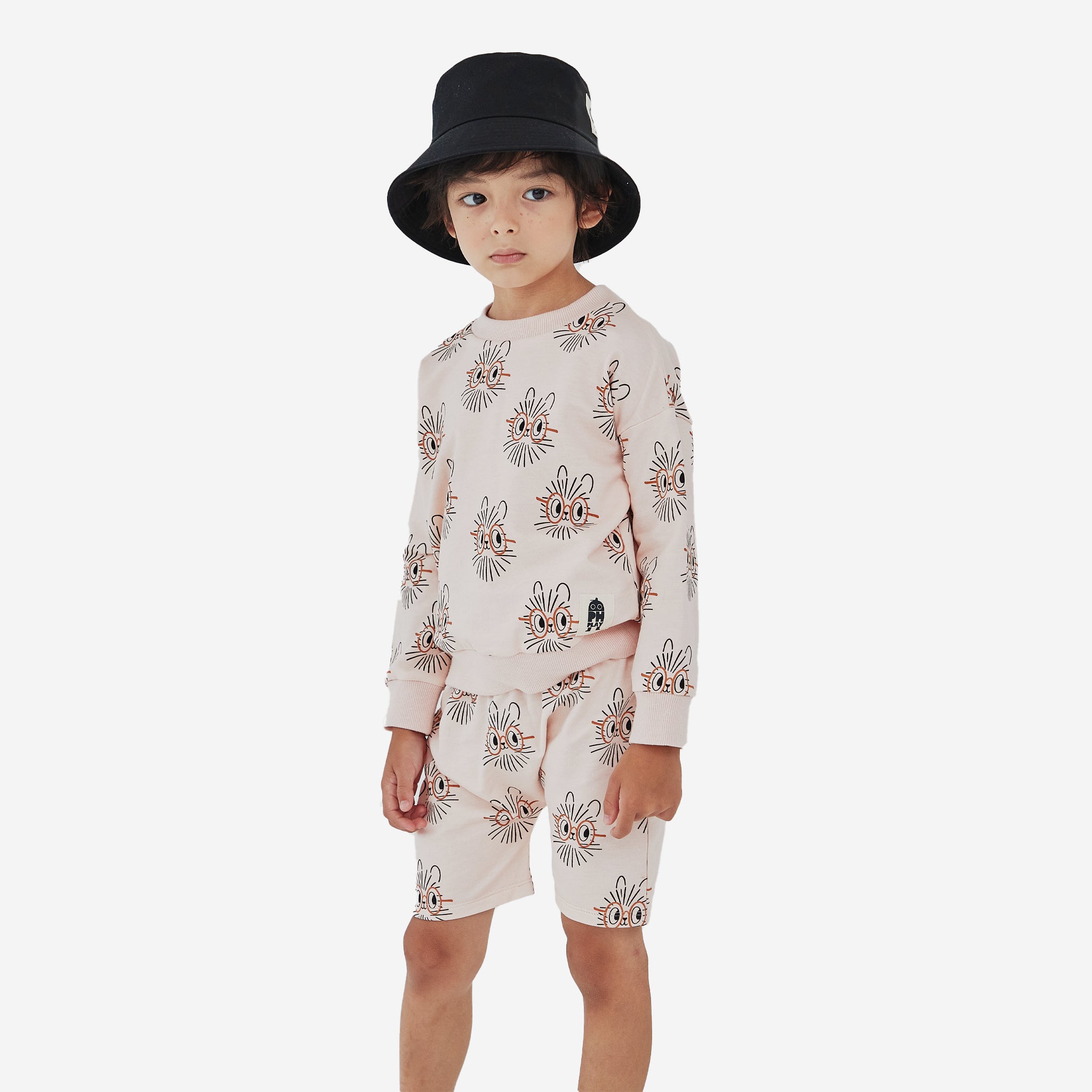 The Hedgehog print boy short has a light peach background with abstract hedgehog faces with orange oval eye glasses.