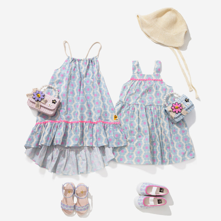 Styled image incluedes ub dress 3 which is made of blue and pink printed flowers, print sandals, Daisy tweed Pearl bag, and sun hat