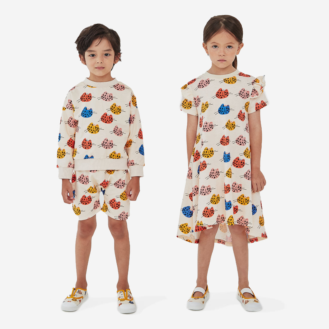 The multi cat print boy short has a cream background with abstract multi color cat faces and elastic belt