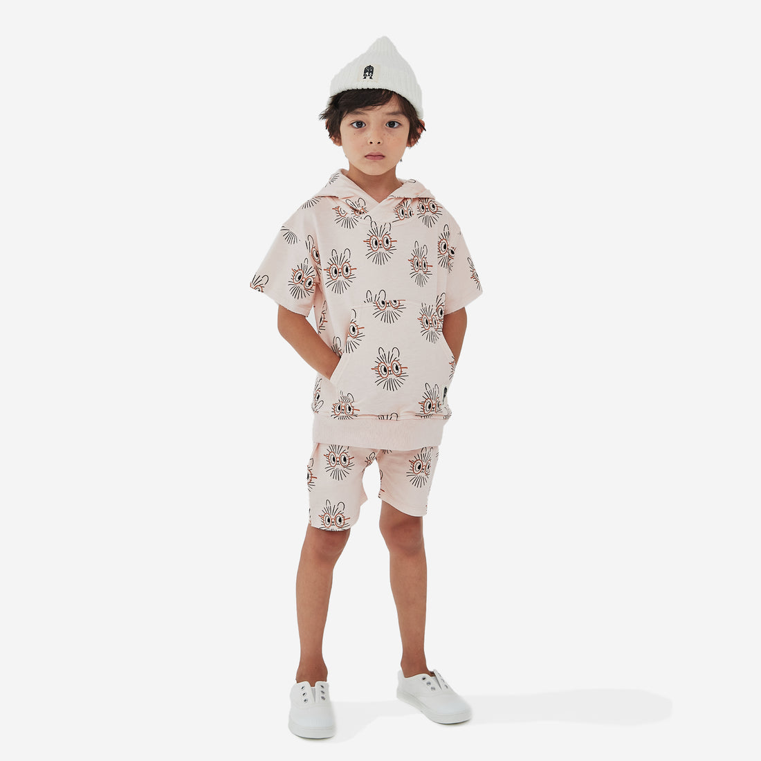 The Hedgehog print boy short has a light peach background with abstract hedgehog faces with orange oval eye glasses.