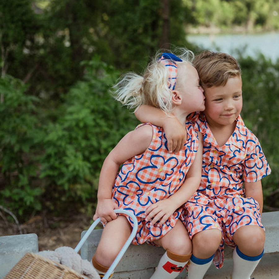 orange checker with blue flowers set includes short sleeves top with buttons on the front and a short 