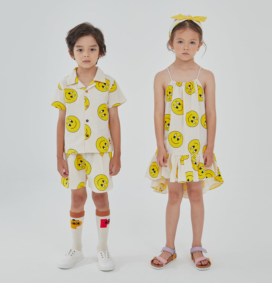 yellow smiley faces on cream background set includes short sleeves top with buttons on the front and a short 