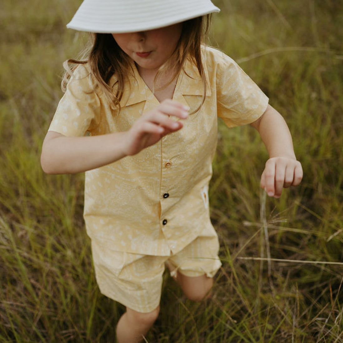 yellow background with white motives set includes short sleeves top with buttons on the front and a short 