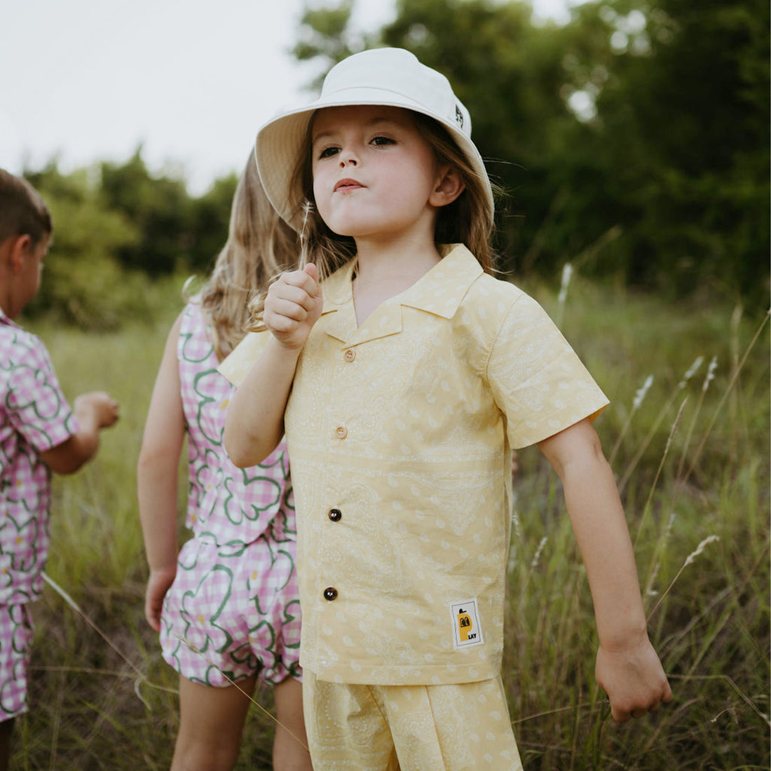 yellow background with white motives set includes short sleeves top with buttons on the front and a short 